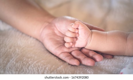Die Hand eines Neugeborenen liegt bei der Mutter. Konzept der Liebe und Fürsorge von Mutter.