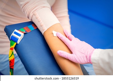 Hand Of Nurse Applying Cotton Swab To Arm Of Young Woman After Blood Sample In The Hospital