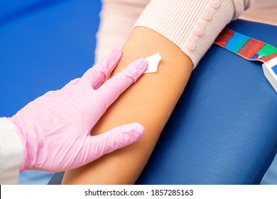 Hand Of Nurse Applying Cotton Swab To Arm Of Young Woman After Blood Sample In The Hospital