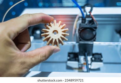 hand with Object of gear printed on 3d printer close-up