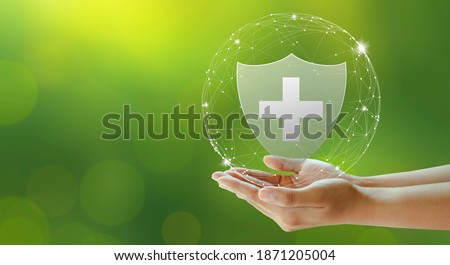 Hand offer medical shield on green background. Family life insurance, Medical care insurance, and Business healthy concepts. Copy space.