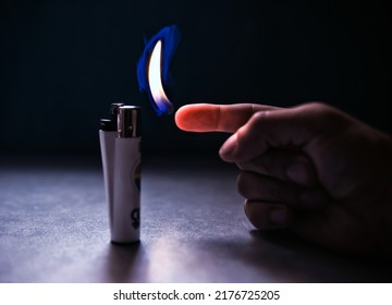 A Hand Offers Fire To A Lighter Without Gas