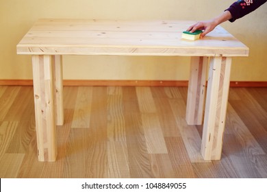 Hand Oiling New Handmade Natural Spruce Tree Wood Table With Sponge For Water And Stain Protection.