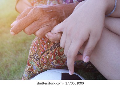 The hand of an old lady using a little finger on the little finger of a childConcepts, attachment and promises from the little finger gestures.