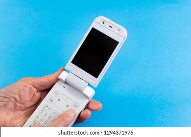 Hand Of An Old Man Who Operates A Folding Type Mobile Phone