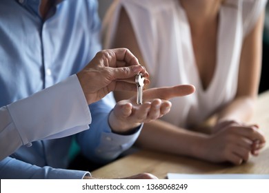 Hand of old realtor broker bank manager give new house keys to young family couple first time home owners make real estate deal concept buy apartment meeting agent, mortgage investment, close up view