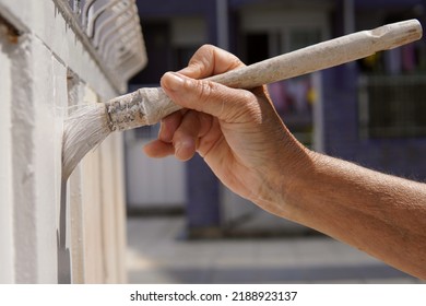 Hand Of An Older Woman Painting A Door White