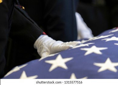 Hand On American Flag Draped On A Casket Of A Fallen Hero.