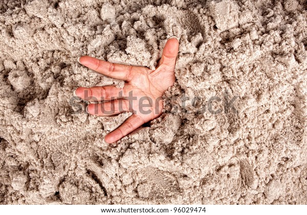 Hand on a\
beach sinking or drowning in\
quicksand