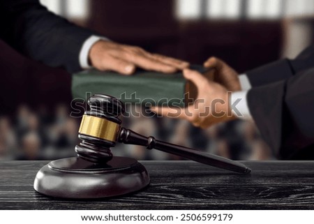 Hand on the Bible in court or the oath on the constitution book. Judge gavel. The witness is sworn in
