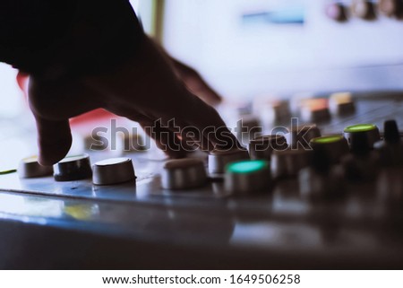 The hand on the button. Pressing the buttons on the remote control.