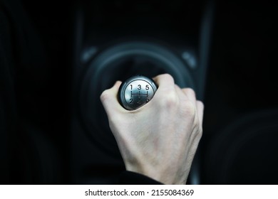 Hand on car gear knob. The driver switches the speed in the car. Hand on gear lever.
