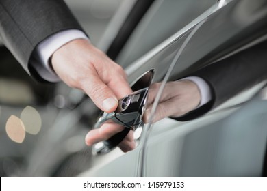 Hand on the car handle. Businessman holding his hand on the casr handle - Shutterstock ID 145979153