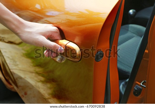 Hand on door handle opening\
a car.