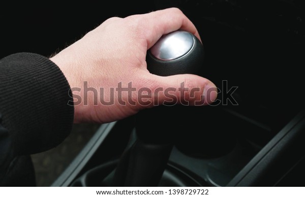 Hand on the gearshift selector in the car,\
close-up. Right-hand drive\
cars.