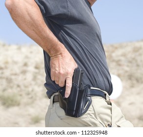 Hand On A Handgun About To Be Pulled From The Holster