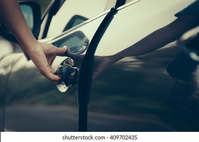 Hand on handle. Close-up of man hand opening a car door. vintage picture style process.