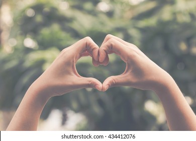 Hand on heart-shaped bokeh background blurred, natural tones vintage style. Show the world you love Love Family between two people.Let's Stay Together happy mother's day, - Powered by Shutterstock