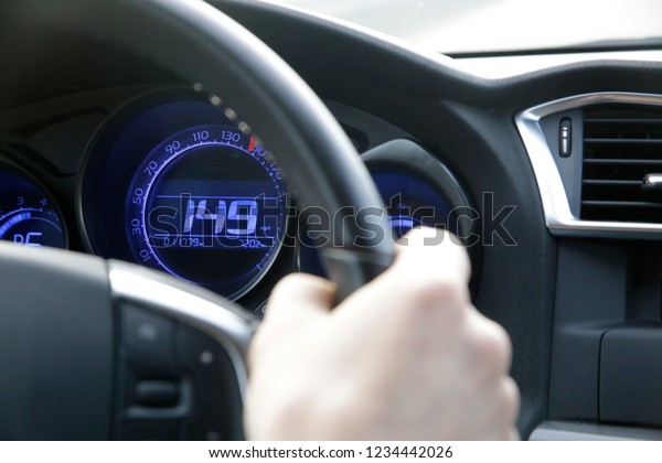 Driver’s\
hand on a steering wheel and speedometer showing speed of 149 miles\
per hour. Close-up photo on the subject of traffic rules, the\
Highway Code and compliance with speed\
limits.