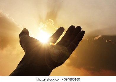 Hand on sunset background success, peace,freedom business concept 