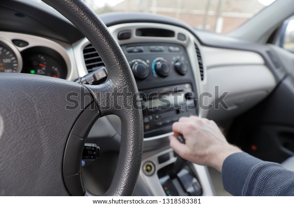 hand on vehicle gear shift,\
gear shift, radio and climate controls - interior, front,\
dashboard