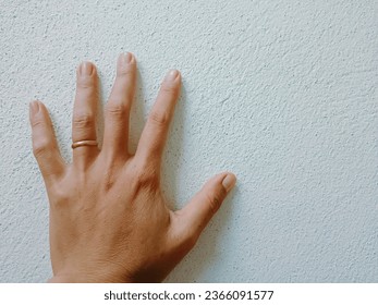 Hand on the wall, hand with a ring on the left ring finger  hands that are tied  with a promise.