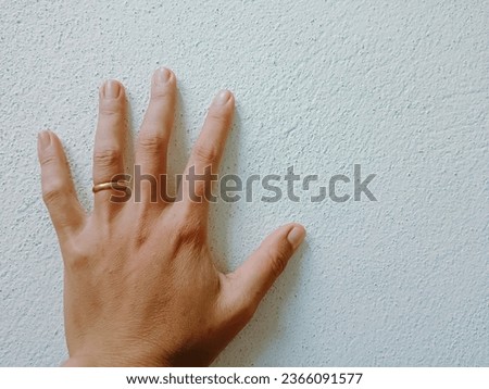 Hand on the wall, hand with a ring on the left ring finger  hands that are tied  with a promise.