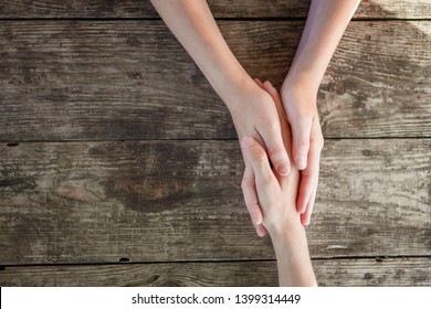 Hand In Hand On Wooden Background, Mutual Aid Concept