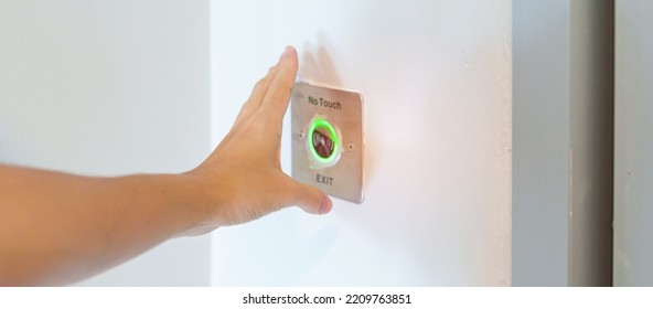 Hand Open The Door By No Touch Sensor Switch On The Wall At Office Or Apartment. Contactless, Modern, Technology And Safety Concept