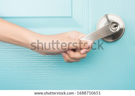 Hand open door knob blue background