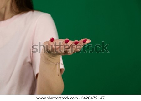 Hand open and ready to help or receive. Gesture isolated with clipping path. Helping hand outstretched for salvation. body parts of a young woman on a green background chromakey