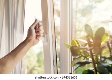 hand open white plastic pvc window at home