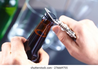 A Hand Opening A Bottle Of Beer