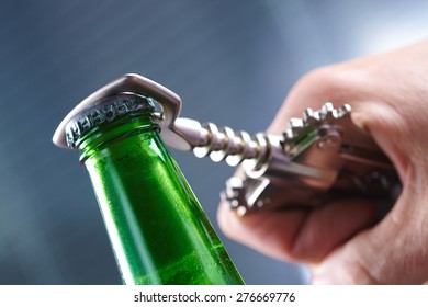 A Hand Opening A Bottle Of Beer