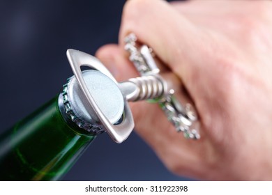 A Hand Opening A Bottle Of Beer