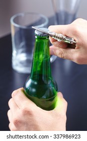 A Hand Opening A Bottle Of Beer