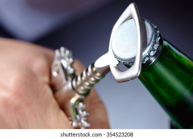 A Hand Opening A Bottle Of Beer