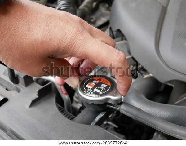 hand opening\
car radiator cap for engine\
cooling.