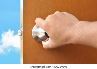 Hand opening the door with sky view behind