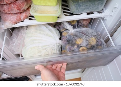A Hand Opening A Drawer Of A Freezer With Frozen Foods, Long-term Food Storage And Inventory At Home.