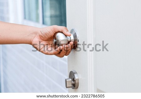 Hand opening Modern white door with chrome metal handle. Elements of interior, close up, To open the door, security, entrance concept.