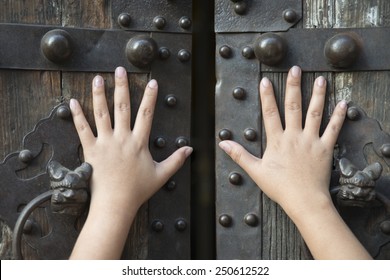 Hand opening the wooden door