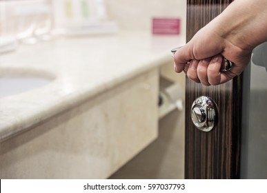 Hand Opens The Door To The Bathroom At The Hotel