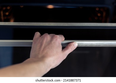 The Hand Opens The Oven Door. Kitchen Equipment.