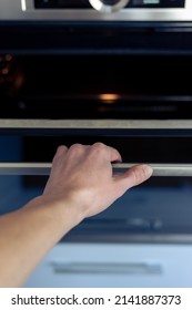 The Hand Opens The Oven Door. Kitchen Equipment.