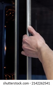 The Hand Opens The Oven Door. Kitchen Equipment.