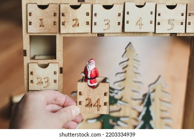 Hand Opens Wooden Advent Calendar