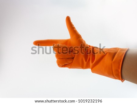 Hand with orange cleaning gloves showing symbolic gestures.
