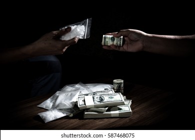 Hand out to send money to buy the drugs, many banknote and drugs on wooden table, concept about the drug problem, drug addiction and has been trading.