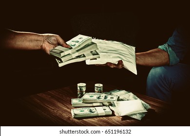 A Hand out to send money to buy the drugs and dealer drugs man send big pack of cocaine, and many banknote and drugs on wooden table, dark vintage style,substance addiction and abuse concept.